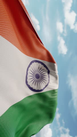 Wavy flag of India blowing in the wind in slow motion. Waving colorful Indian flag team symbol abstract vertical background. Blue sky with clouds. World countries flying flags concept