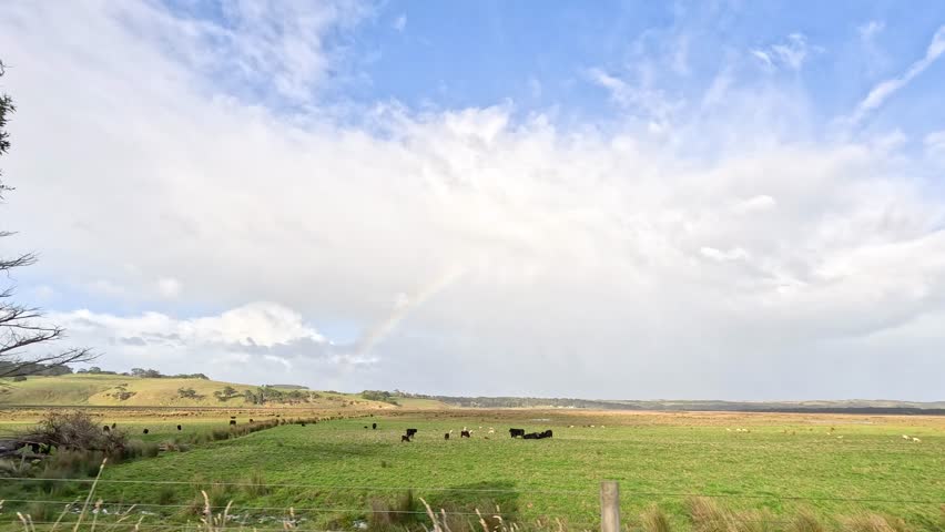 A rainbow appears over a scenic landscape