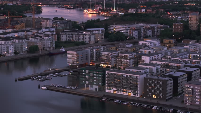 Aerial views of Stockholm reveal a stunning cityscape at twilight, blending modern and historic architecture, softly illuminated by the warm glow of evening lights