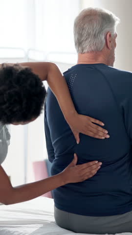 Senior man, physiotherapist and back pain with woman for recovery, massage or muscle development. Elderly patient, physical therapy and helping hand for rehabilitation, injury and wellness at clinic