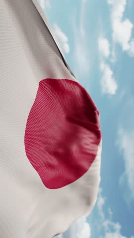 Wavy flag of Japan blowing in the wind in slow motion. Waving colorful Japanese flag team symbol abstract vertical background. Blue sky with clouds. World countries flying flags concept