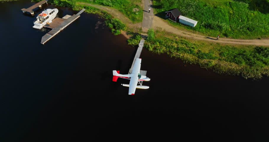 Drone circling a seaplane docked at lake Inari, summer evening in Finland