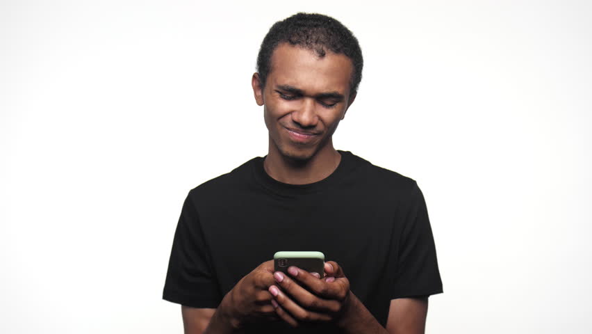Man reacting to smartphone with a smirk and shrug