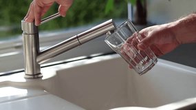 Close up of male hands pouring tap water into a glass in the kitchen - Powered by Shutterstock - Get 15% off with code: PIKWIZARD15