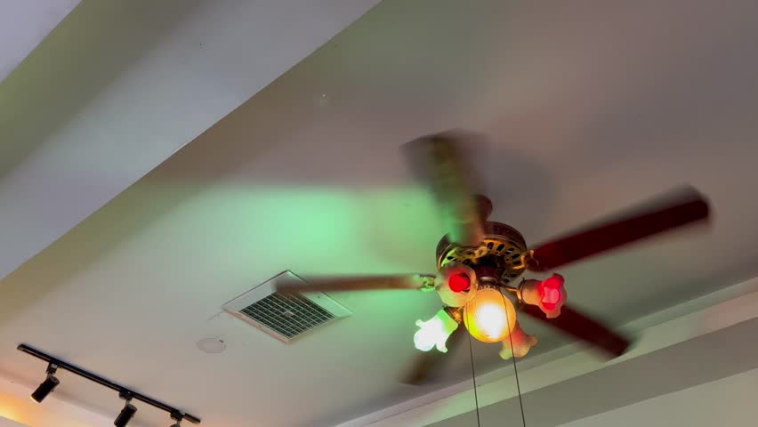 a spinning ceiling fan and warm colorful lighting. Vintage ceiling fan with colorful bulp.