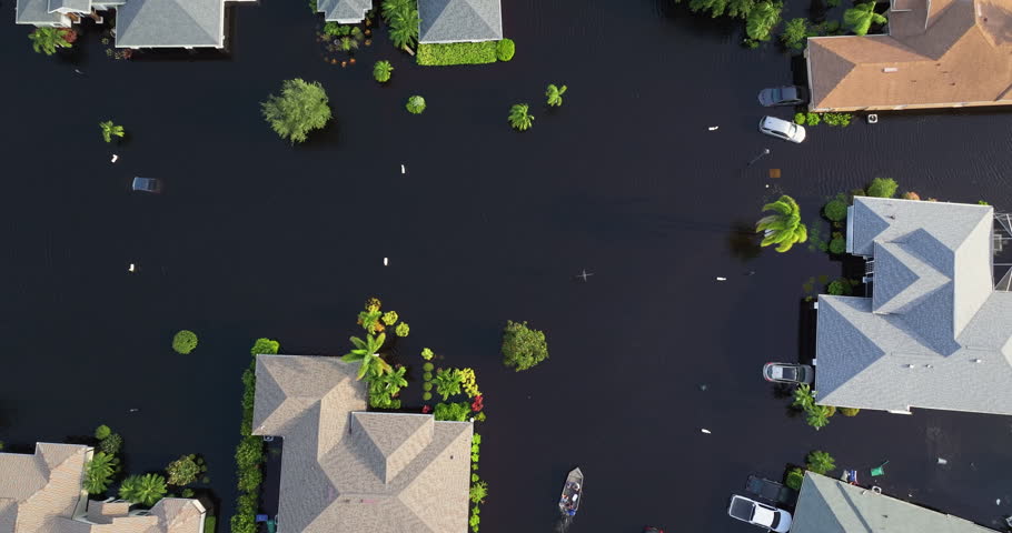 People riding motor boat on flooded street in Sarasota, Florida after hurricane Debby torrential rainfall drowned rural homes in residential area.