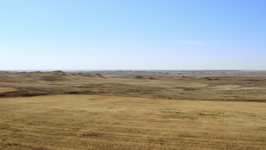 An Expansive Prairie Landscape Spread Out Beneath a Beautifully Clear Blue Sky Above. Stock Clip
