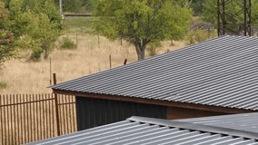 Light rain falling on corrugated steel rooftop in a serene rural landscape. - Powered by Shutterstock - Get 15% off with code: PIKWIZARD15