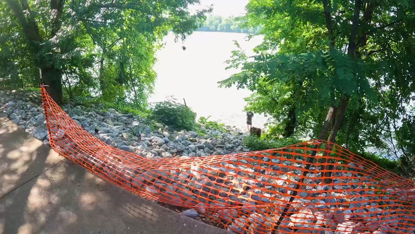 footage of a gorgeous summer landscape in the park along a footpath near the rippling waters of the Tennessee River surrounded by lush green trees, grass and plants with blue sky and clouds