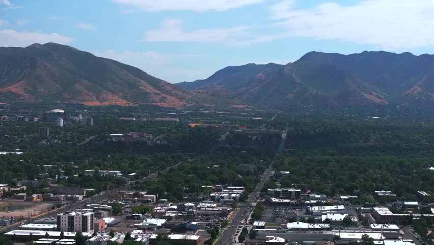 Wasatch Mountain Range downtown Salt Lake City SLC Utah aerial drone USA summer blue sky morning afternoon The Great Salt Basin Lake County region LDS highways neighborhoods buildings upward motion