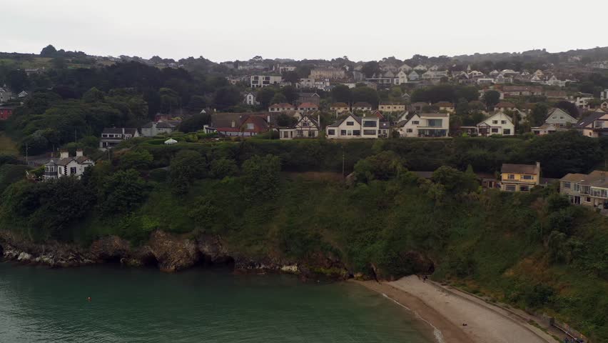 Aerial trucking pan along idyllic coastal community in Howth North Dublin Ireland on misty day