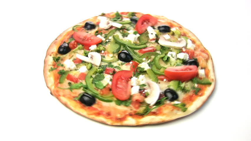 Vegetarian pizza rotate, showing all of its stuffing: peppers, olives, tomatoes,