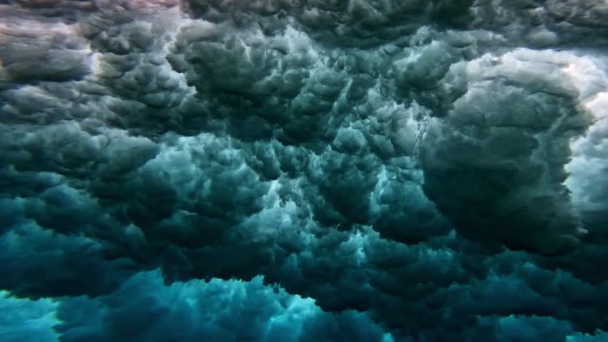 Underwater view of tube wave breaking over coral reef with spinning vortex. powerful nature, strong wave. Abstract bubbles texture, pattern, slow motion 4k.