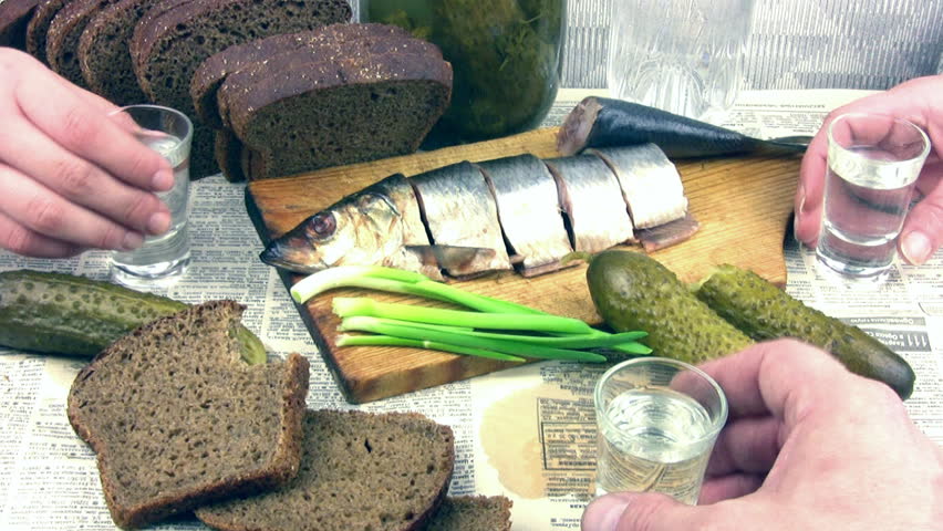 Vodka, herring, pickles, black bread on the tablecloth from the newspaper. Three