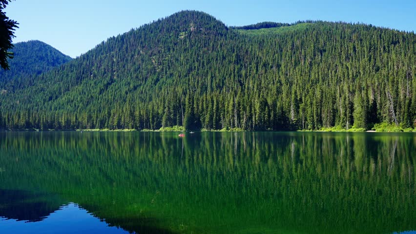 Landscape of Cooper lake mountain. Kayak boat. Nature landscape. Cooper Lake in Cascade Mountains. Scenic nature with kayak boat at Cooper lake. Cooper lake with mountain landscape. Wild nature