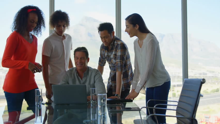 Clock animation over diverse business team collaborating around laptop in office. Teamwork, collaboration, technology - Powered by Shutterstock - Get 15% off with code: PIKWIZARD15