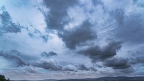 Dark clouds swirl across a deep blue sky as a weather front moves over the landscape, trees silhouetted below. - Powered by Shutterstock - Get 15% off with code: PIKWIZARD15