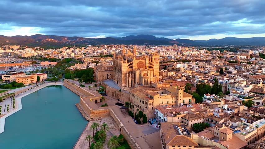 flying towards cathedral of Palma de Mallorca at sunrise, aerial Palma de Mallorca cityscape. Cathedral of Santa Maria, Royal Palace of La Almudaina. Balearic Islands. Spain. High quality 4k footage