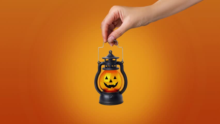 Halloween autumn concept. Minimal looped horizontal animation banner with pumpkin lantern in a hand. Orange Background copy space