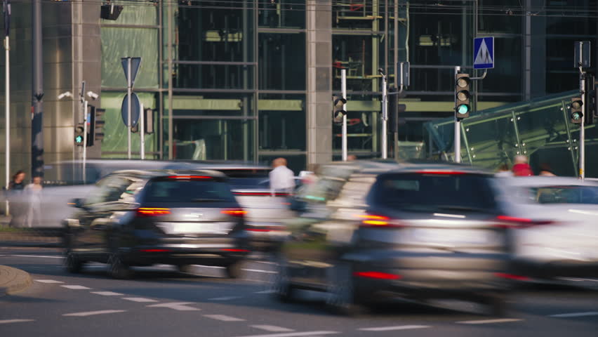 Time lapse of busy crossroad in city downtown pedestrians crossing crosswalk during sunny evening rush hour, unrecognizable people crowd, vehicles traffic, long exposure, blurred car brands