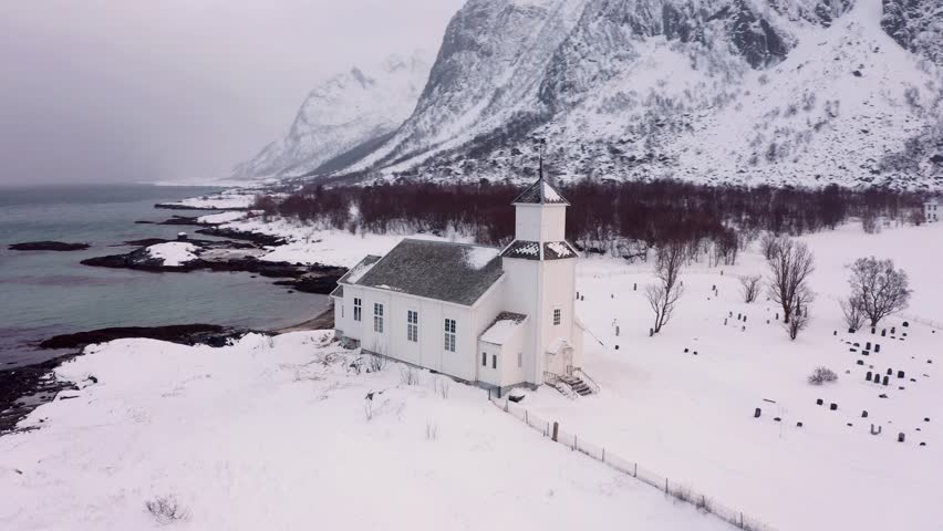 4k drone flight point of view (Ultra High Definition) of Gimsoy Church, Norway, Europe. Gloomy winter scene of Lofoten Islands. Picturesque morning seascape of Norwegian sea.