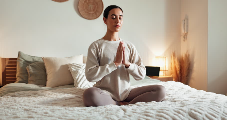 Calm woman, bed and yoga with meditation for zen, awareness or spiritual wellness at home. Young, female person or yogi in relax or lotus pose for exercise, health and wellbeing in bedroom at house
