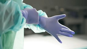 close-up of modern clinic in a bright, spacious operating room, an assistant surgeon helps to put on sterile gloves - Powered by Shutterstock - Get 15% off with code: PIKWIZARD15