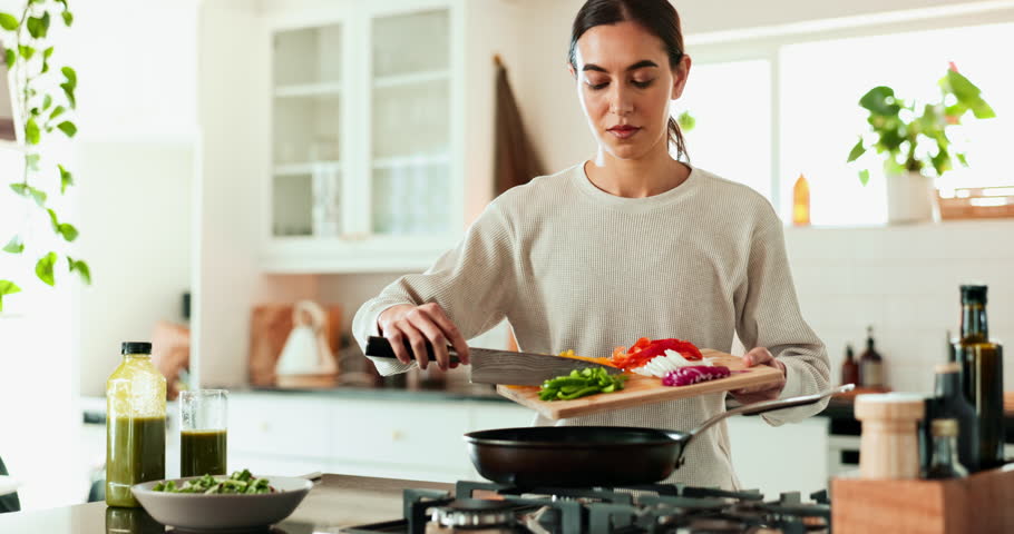 Woman, wood board and cooking with vegetables in kitchen for meal prep, health lunch and nutrition in morning. Chef, knife and pan for organic food process, salad ingredient and vegan brunch at house