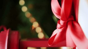 Wrapped gift in craftool paper with red ribbon, champagne and Christmas decorations rotating, close up. Background with Christmas and new year decorations. Vertical video - Powered by Shutterstock - Get 15% off with code: PIKWIZARD15