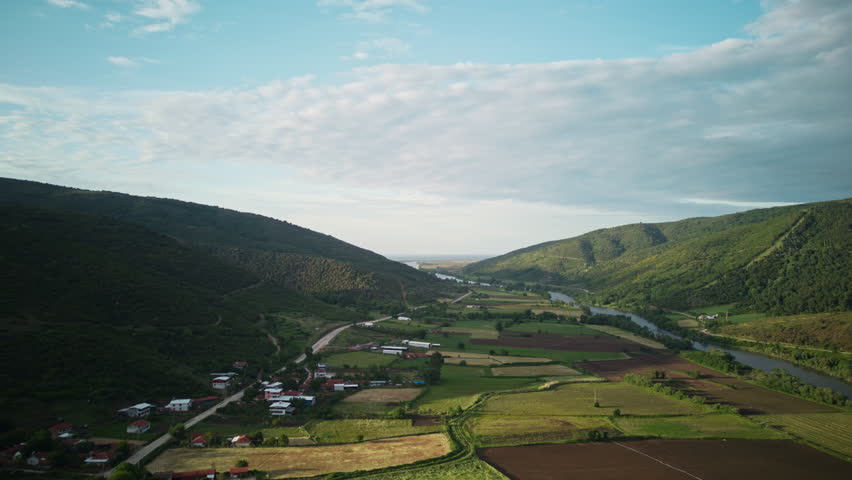 Hyperlapse of the Big Sky Over Fields Between a Village and River Near Bursa-Karacabey. Aerial View. Shadows of Dramatic Clouds Moving Over the Green Fields.