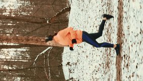 Woman in sports clothes and headphones jogging in park at winter. Female athlete running outdoors and doing fitness exercises. Vertical video - Powered by Shutterstock - Get 15% off with code: PIKWIZARD15