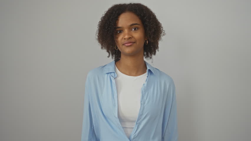 Woman, young african american woman wearing shirt standing and winking with a happy and cheerful face looking at the camera with a sexy expression over isolated white background
