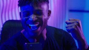 African American man guy male winner success champion looking holding mobile phone smartphone app victory win achieve successful winning good news celebrate modern cyber technology neon futurism room - Powered by Shutterstock - Get 15% off with code: PIKWIZARD15