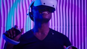 Excited African American man guy male gamer gaming vr play virtual reality glasses helmet internet game modern cyber technology neon futurism indoors futuristic metaverse playing software AR designer - Powered by Shutterstock - Get 15% off with code: PIKWIZARD15