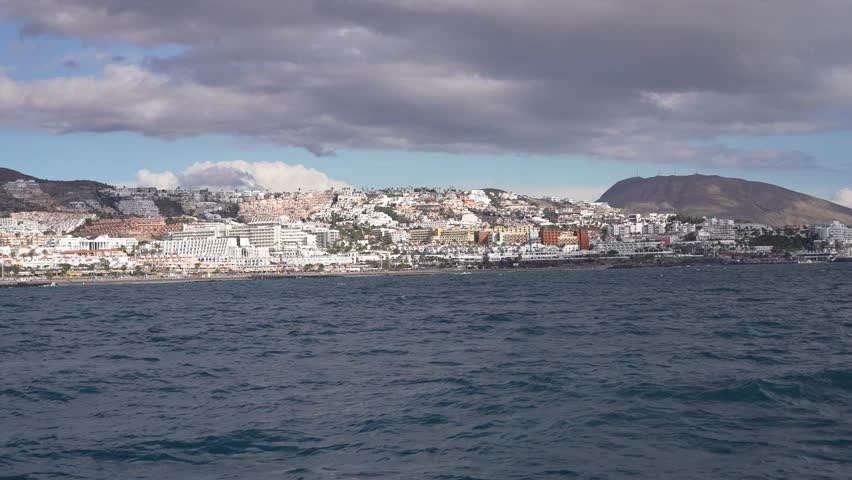 Adeje coastline with La Pinta beach in Tenerife Island Spain with hotels and resorts, Wide view from boat