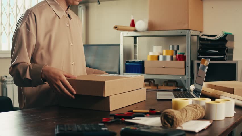 E-commerce storage shop, woman packing goods and clothes for second hand delivery market, dedicated Packaging and Shipping Workspace with Supplies and Technology for efficiency, online sales.