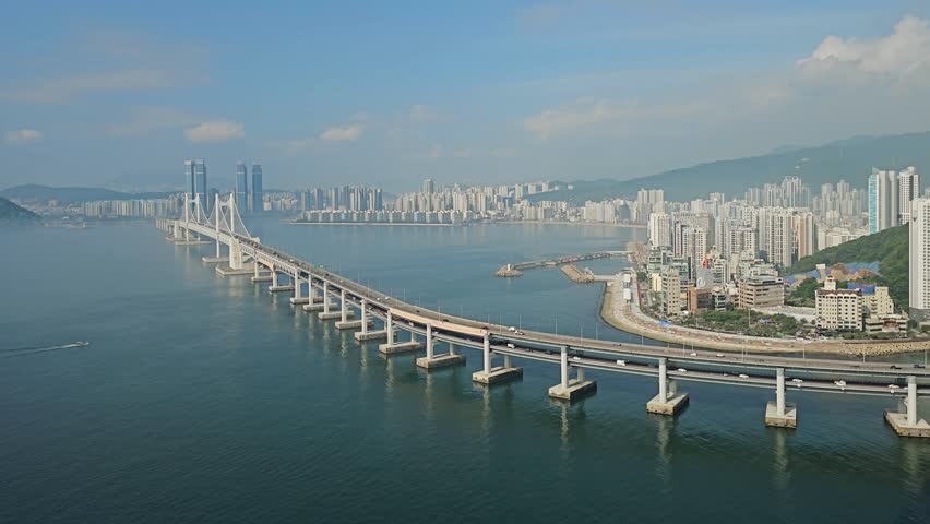 Cars Driving Through The Gwangan Bridge Over The Sea With City Buildings In Busan, South Korea. - slow zoom-in shot