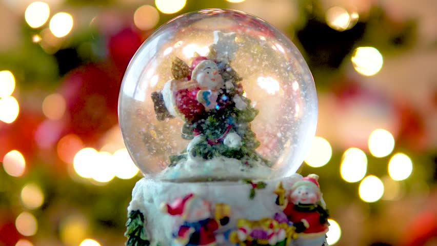 Christmas Theme, Snow Globe with Snowman and Christmas Tree and Blurred Lights in Background