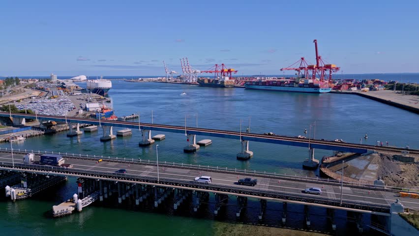 Drone view of Fremantle shipping port with car traffic bridge on sunny day, Perth, Western Australia
