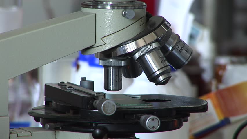 Researchers working in lab with microscope, close up