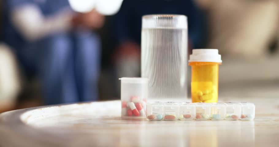Healthcare, medicine and pills in bottle on table for pharmaceutical, closeup and treatment of disease. Medical, drugs and water with capsule in nursing home for prescription, medication and recovery