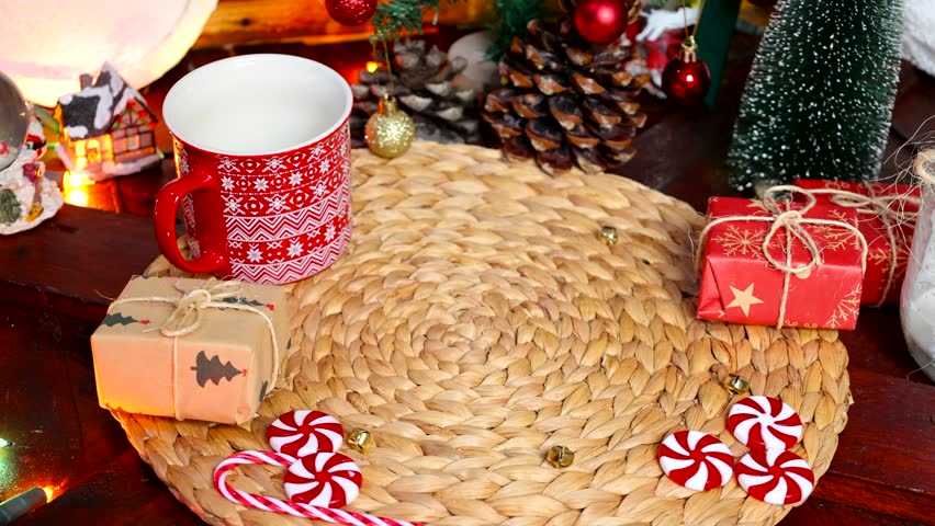 Male hand placing plate with Christmas cookies on a table decorated with Christmas decorations in the background, Christmas food concept
