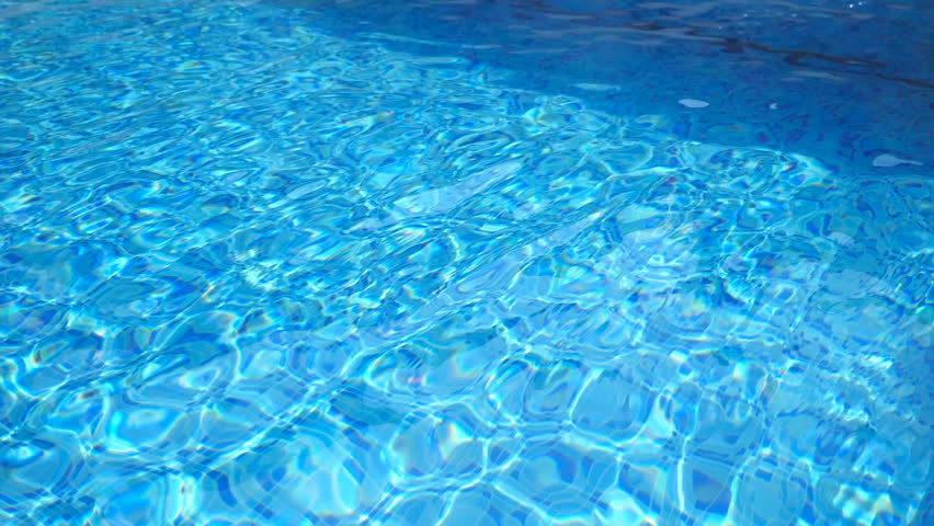 Unrecognizable woman jumping in pool and splashing crystal clear water. Young girl in swimsuit swimming under water in basin of hotel. Lady relaxing during summer vacation. Slow motion Close up
