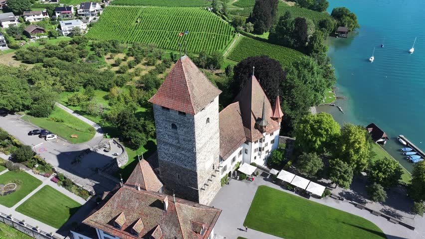 Aerial - Spiez Castle surrounded by vineyards in Kanton Bern, Switzerland