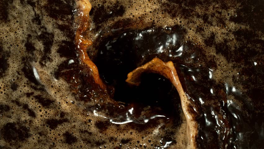 Super Slow Motion Detail Shot of Coffee Foam Swirling . Filmed on High Speed Cinematic Camera at 1000 FPS .