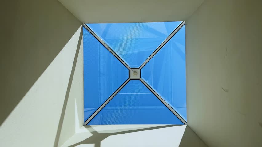 A modern skylight lets natural light flood into a room with a bright, geometric design