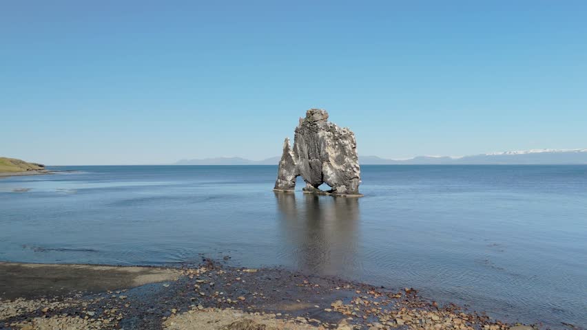 Breathtaking Aerial Footage Of Hvitserkur, The Famous Troll Rock, Showing Its Massive Creature-Like Structure Rising From The Ocean Waters In Northern Iceland.
