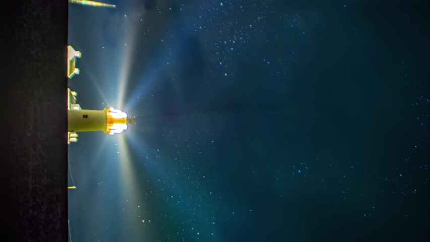Vertical 4K timelapse of a lighthouse under the Milky Way, with light flares from the beacon and drifting clouds.