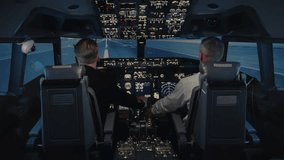 Pilots Sit in Cabin Seats and Take Off on Plane in City Airport to Night Time Sky. Focused Men Using Technology of Airplane Control Panel to Flight Study. Aircraft Aviators Fly in Operating Cockpit - Powered by Shutterstock - Get 15% off with code: PIKWIZARD15