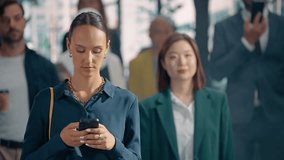 Lively Mix of Pedestrians From Different Backgrounds Walk on a City Street, Reflecting the Energy of the Urban Environment. Young Male and Female Use Smartphones as They Navigate the Crowded Sidewalk - Powered by Shutterstock - Get 15% off with code: PIKWIZARD15